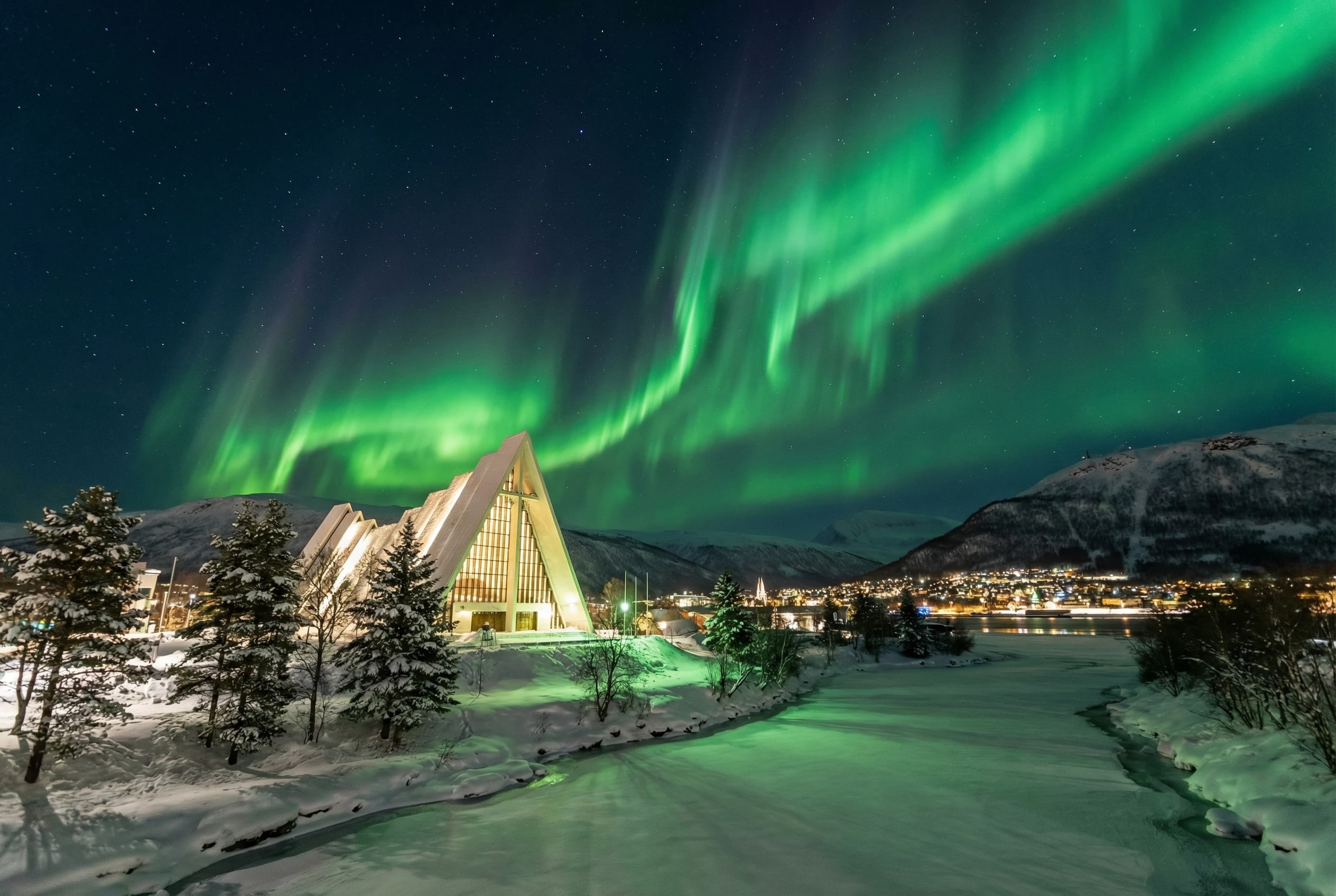 Arctic Cathedral Tromsø illuminated by Northern Lights in winter - Norway's iconic modernist church architecture